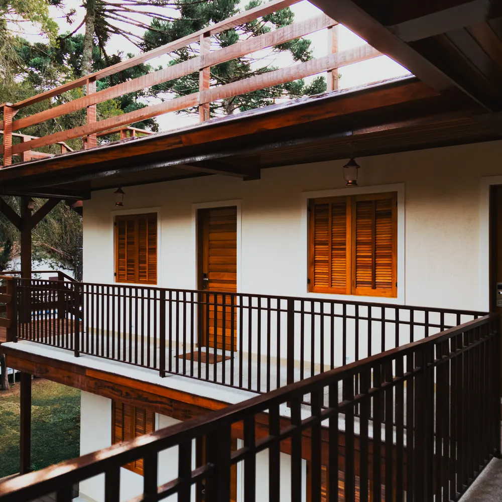 Guest rooms with wooden doors along a shaded balcony